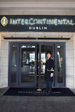 A hotel entrance with a uniformed staff member standing in front. - InterContinental Dublin by IHG (Dublin)