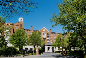 Experience the charm of this historic building with its symmetrical windows and central entrance, set amidst beautifully maintained gardens and a paved pathway.