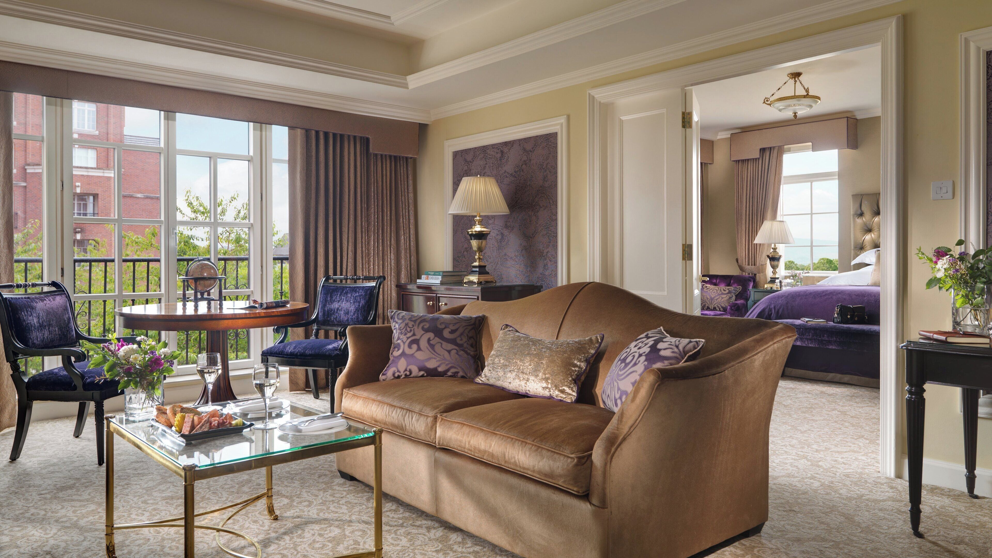 A well-appointed living room with a leather sofa, a glass coffee table, and a view of a balcony.