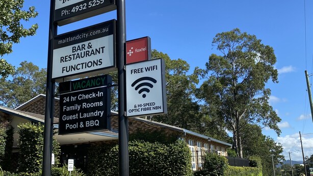 A sign for Old Maitland Inn with amenities like a bar, restaurant, and free WiFi.