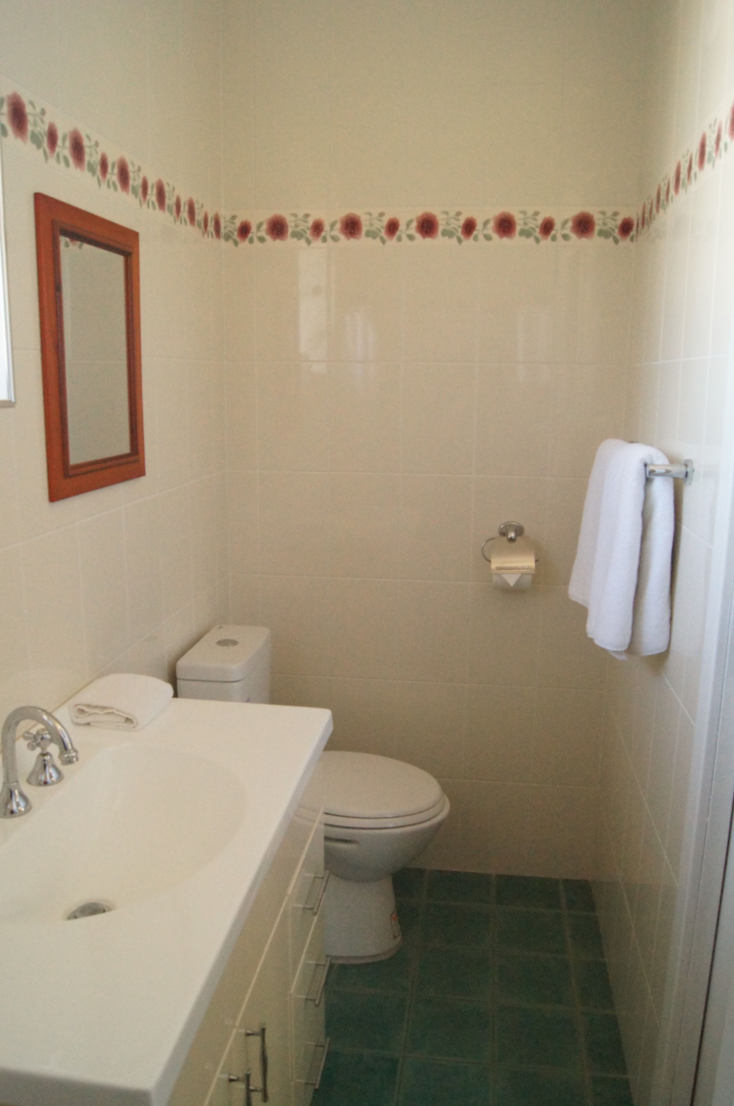 A bathroom with a sink, toilet, and shower.