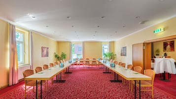 A conference room with a long table, chairs, and a red carpet.