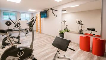 A gym with exercise equipment, a mirror, and a wooden ladder.