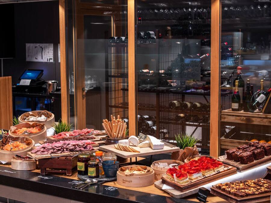 A buffet with various food items and a wine selection.