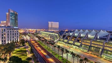 A modern train station with multiple tracks and a large, illuminated building in the background.