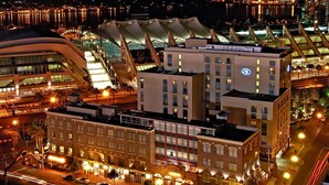 A multi-story hotel with a modern architectural design, featuring a prominent curved structure and a rooftop terrace. - Hilton San Diego Gaslamp Quarter (San Diego)