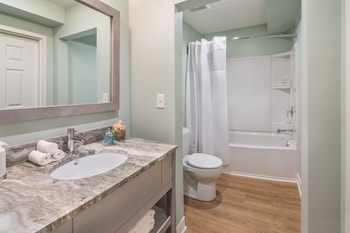 Features a marble vanity, separate shower, and toilet. at The Palms Oceanfront Hotel