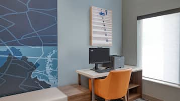Un espacio de oficina moderno con un escritorio, computadora y silla, un mapa en la pared y una ventana con persianas.