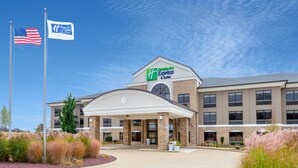 A Holiday Inn Express & Suites building with a brick facade, a covered entrance, and a flagpole with the American flag. - Holiday Inn Express & Suites Wadsworth by IHG (Wadsworth)