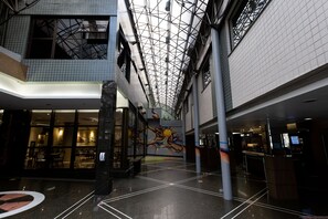 Tilava aula, jossa on korkea katto, seinämaalaus ja vastaanottoalue.