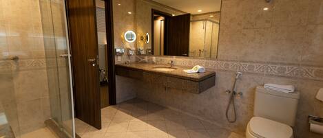 A modern bathroom with a glass shower enclosure, a vanity with a mirror, and a toilet.