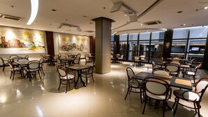 A spacious restaurant with high ceilings, modern lighting, and a view of the city through large windows. - Master Porto Alegre Hotel - Av Carlos Gomes, Proximo Consulado Americano (Porto Alegre)