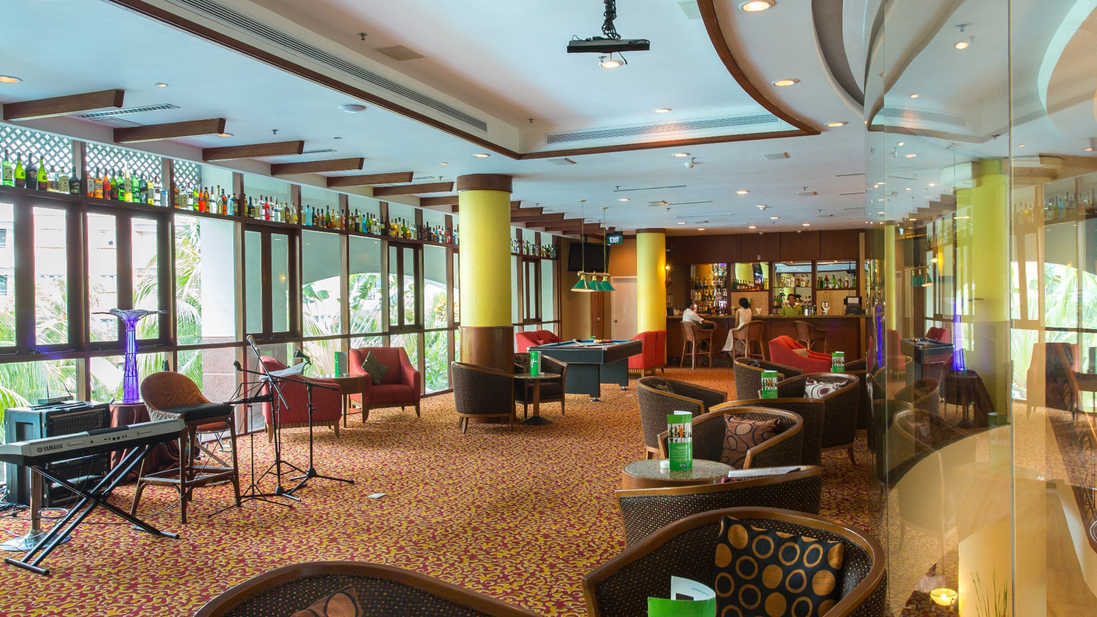 A spacious lobby with a pool table, comfortable seating, and a bar area.