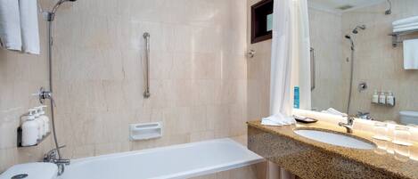 A modern bathroom with a bathtub, two sinks, a shower, and a toilet.