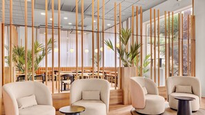 Un interior moderno con asientos, mesas y paneles de madera verticales.