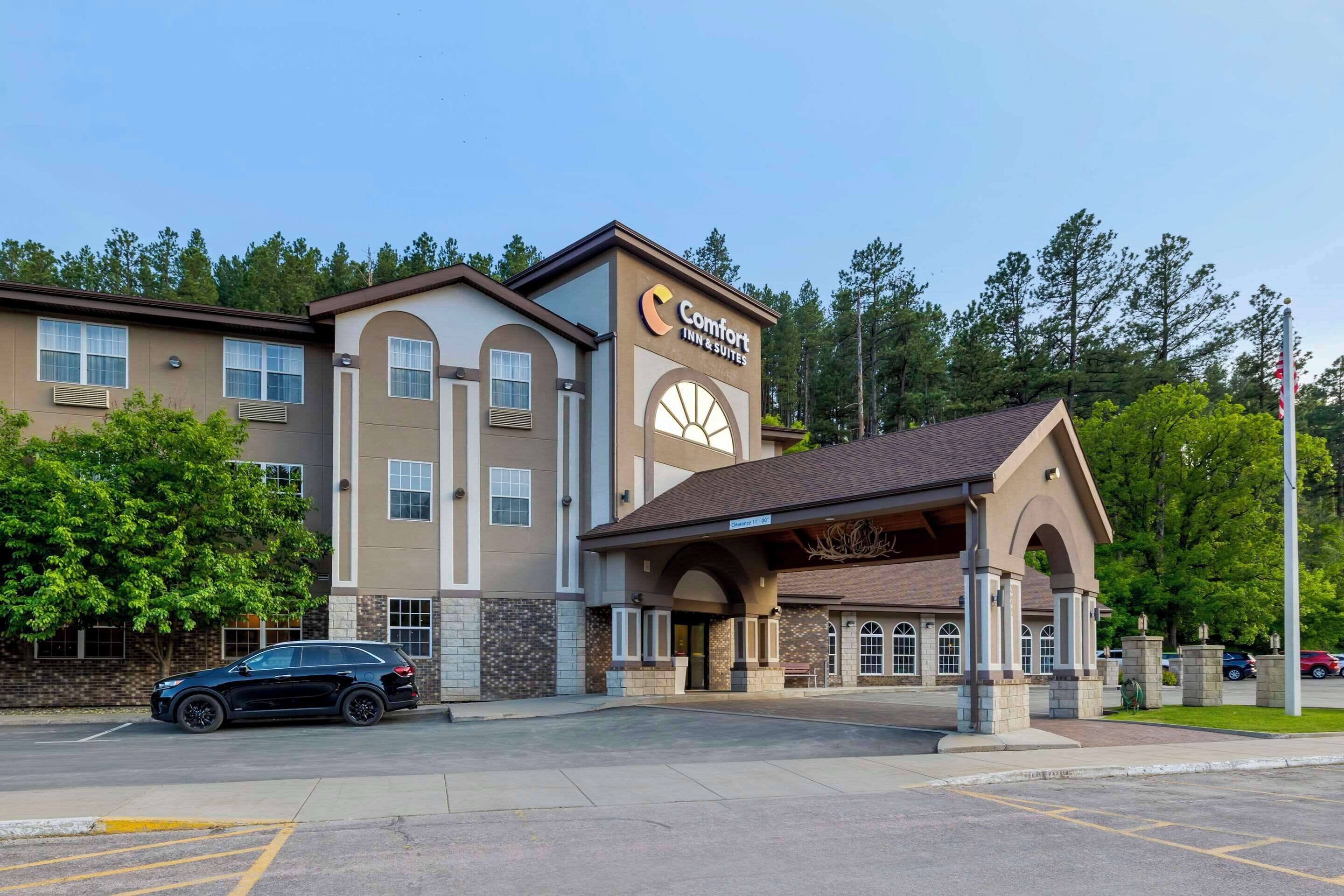 A Comfort Inn & Suites hotel with a modern design, featuring a prominent entrance and a parking lot.