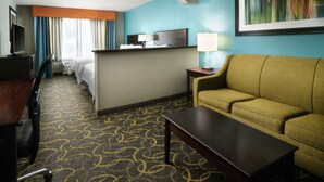 A hotel room with a bed, a desk with a chair, a sofa, a TV, and a lamp. - Holiday Inn Express & Suites DFW - Grapevine by IHG (Grapevine)
