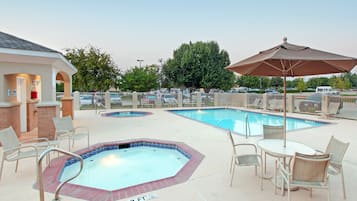 Una piscina al aire libre, sillones reclinables de piscina