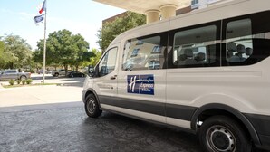 A white van parked under a covered area with a sign indicating it is a Holiday Inn Express & Suites. - Holiday Inn Express & Suites DFW - Grapevine by IHG (Grapevine)