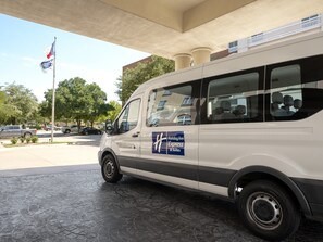 A white van parked under a covered area with a sign indicating it is a Holiday Inn Express & Suites. - Holiday Inn Express & Suites DFW - Grapevine by IHG (Grapevine)