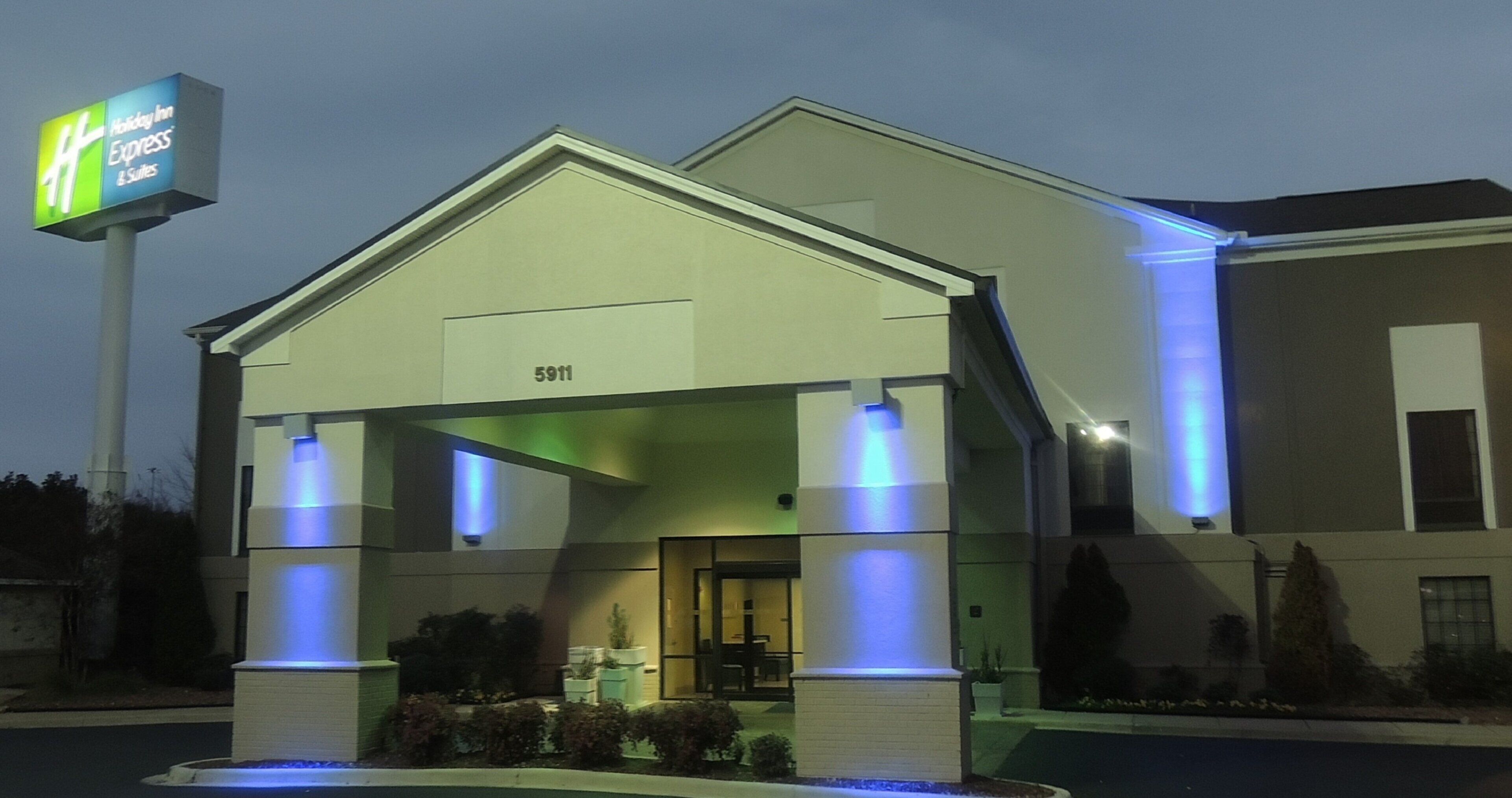 A Holiday Inn Express & Suites building with a modern design, featuring a prominent entrance and a signboard.