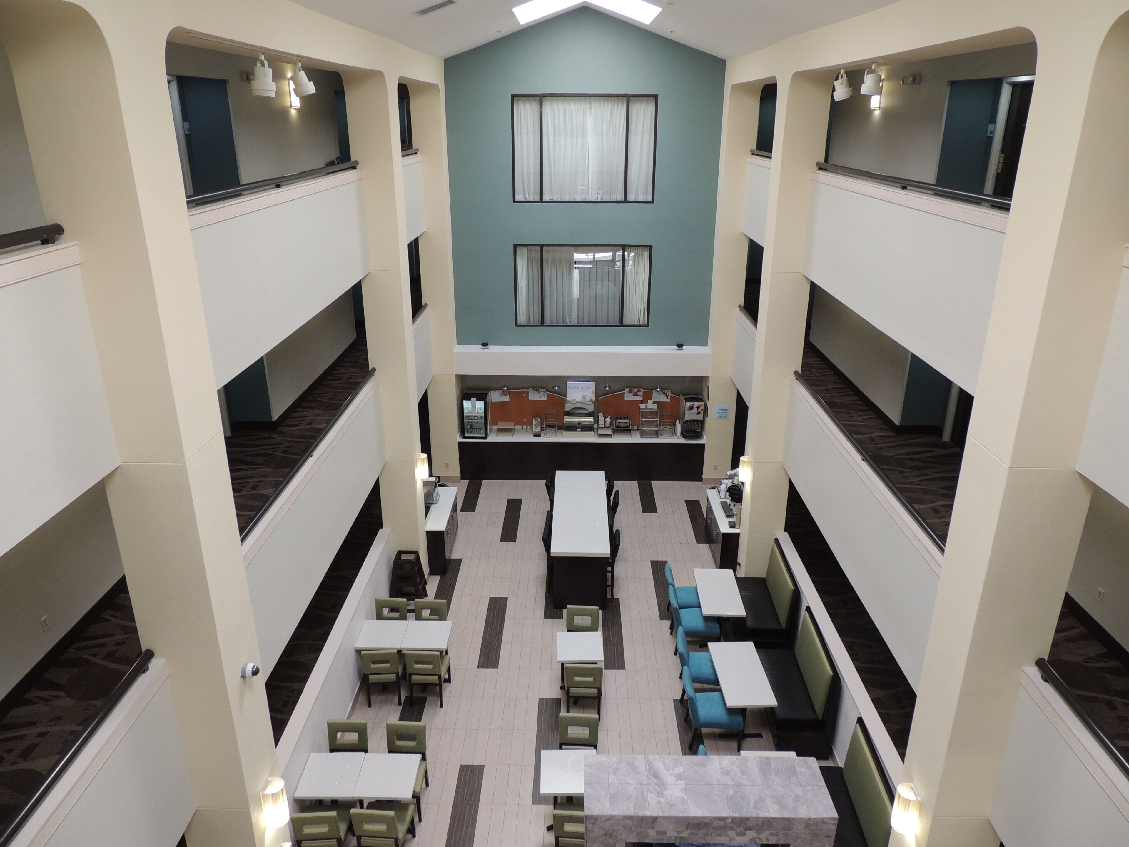 A multi-level dining area with tables and chairs, a counter, and a view of the upper floor.