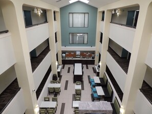A multi-level dining area with tables and chairs, a counter, and a view of the upper floor.
