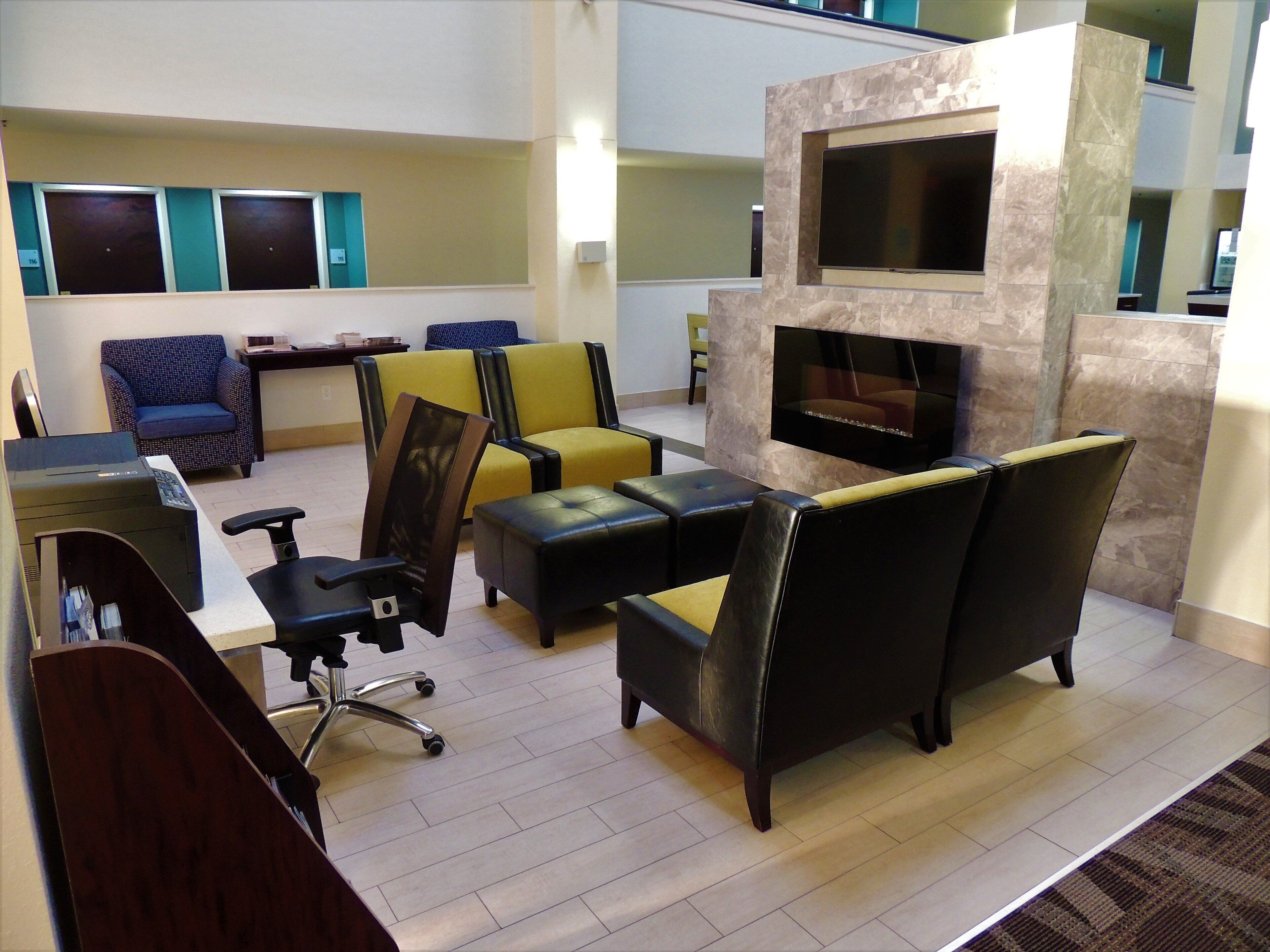 A modern lounge area with seating, a fireplace, and a flat-screen TV.