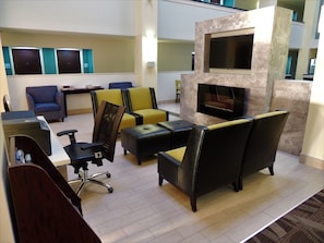 A modern lounge area with seating, a fireplace, and a flat-screen TV. - Holiday Inn Express & Suites Birmingham Trussville by IHG (Birmingham)