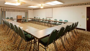 A conference room with a long table, green chairs, patterned carpet, ceiling fans, and a projector screen. - Holiday Inn Express & Suites Birmingham Trussville by IHG (Birmingham)