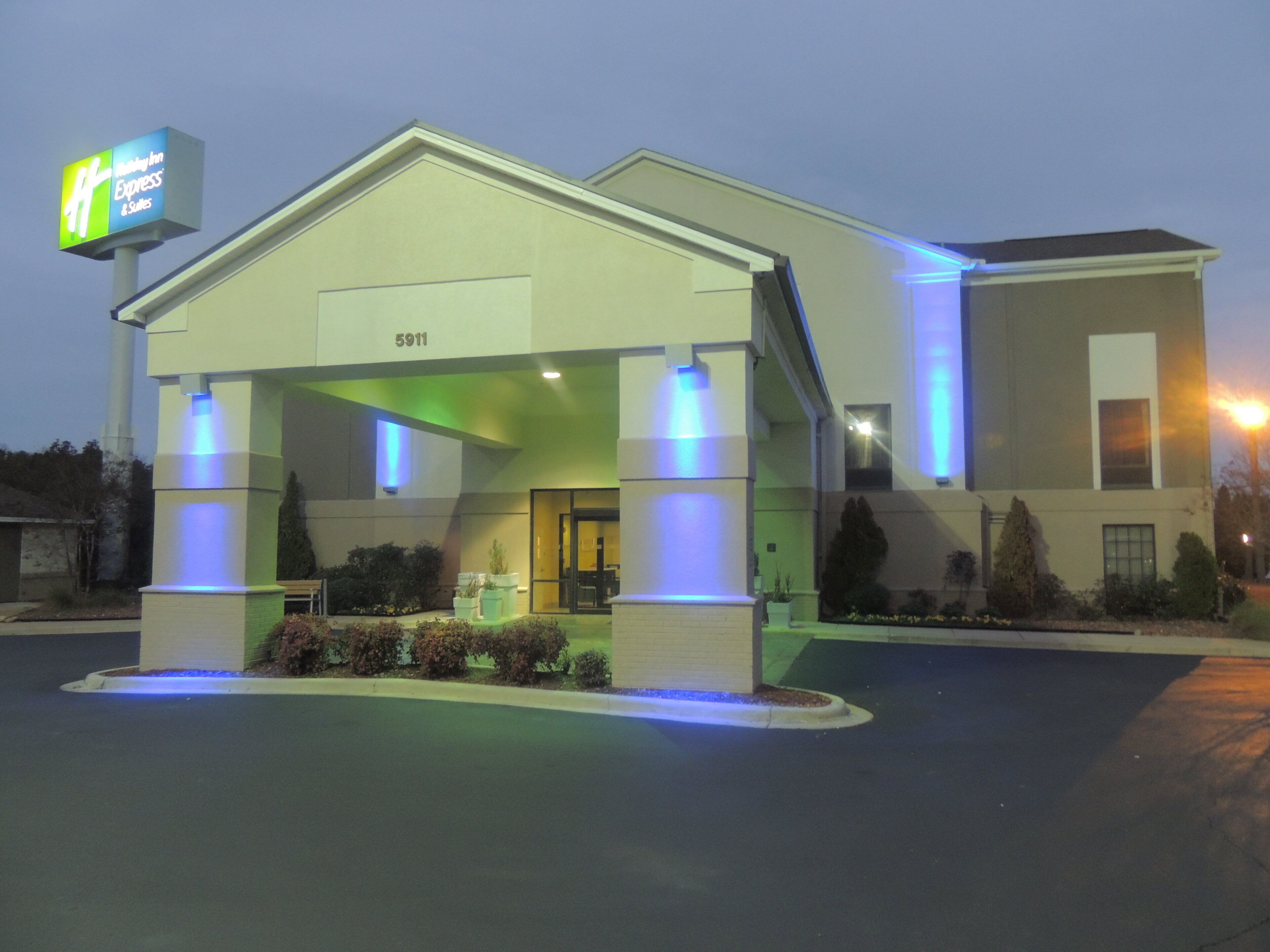 A hotel with a covered entrance, a signboard, and a number '5911' on the building.