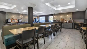 A modern restaurant with booths and tables, a kitchen area, and a large window. - Best Western Plus Pocomoke City (Pocomoke City)
