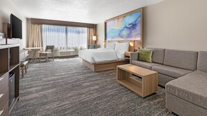 A hotel room with a bed, a sofa, a TV, a desk, and a large window. - Best Western Plus Pocomoke City (Pocomoke City)