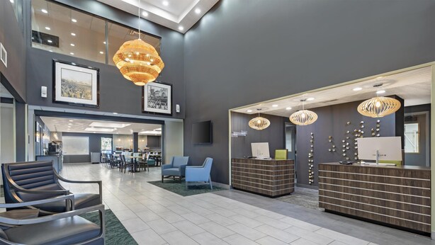A modern lobby with a reception desk, seating area, and artwork on the walls. - Best Western Plus Pocomoke City (Pocomoke City)