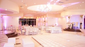 A spacious indoor venue with multiple round tables and chairs, a central stage, and a well-lit dance floor. - iStay Hotel Ciudad Victoria (Ciudad Victoria)