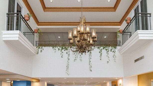 A spacious lobby with a high ceiling, a chandelier, and a reception desk. - iStay Hotel Ciudad Victoria (Ciudad Victoria)