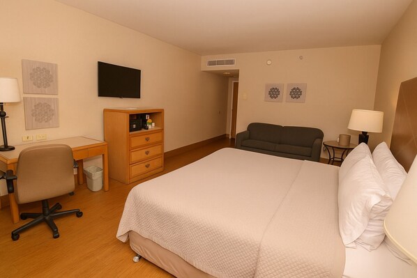 A hotel room with a bed, a desk, a chair, a sofa, and a television. - iStay Hotel Ciudad Victoria (Ciudad Victoria)