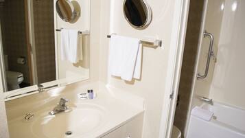 A bathroom with a sink, mirror, and towel rack.