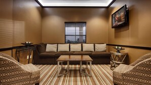 Un salon moderne avec un canapé marron, des coussins à rayures, une table basse et des fauteuils à motifs.