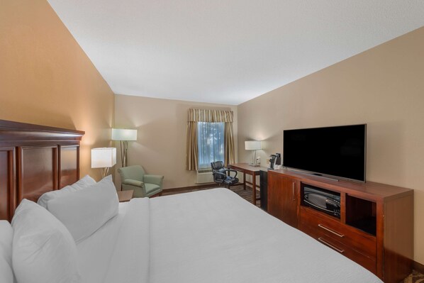 A hotel room with a large bed, a television, a desk with a chair, and a window with curtains. - Best Western Plus Russellville Hotel & Suites (Russellville)