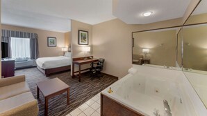 Une chambre d’hôtel avec un lit, un bureau, une chaise et une grande baignoire.