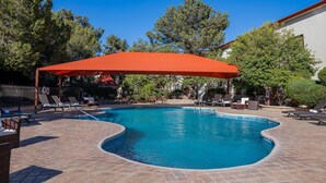A swimming pool with lounge chairs and a red canopy. - Holiday Inn Express Chihuahua by IHG (Chihuahua)