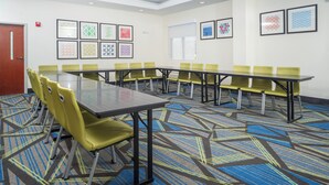 A conference room with a long table, multiple chairs, patterned carpet, and framed artwork on the walls. - Holiday Inn Express Clayton (Se Raleigh) by IHG (Garner)