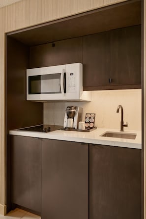A compact kitchen with a microwave, coffee maker, and a sink. - DoubleTree by Hilton North Vancouver (North Vancouver)