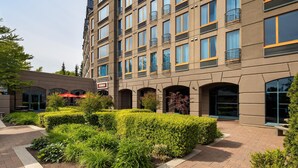 Un hotel moderno a più piani, con un design architettonico elegante, balconi e un cortile curato.