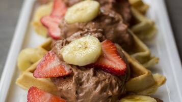 A dessert plate with chocolate ice cream and banana slices on a white plate.