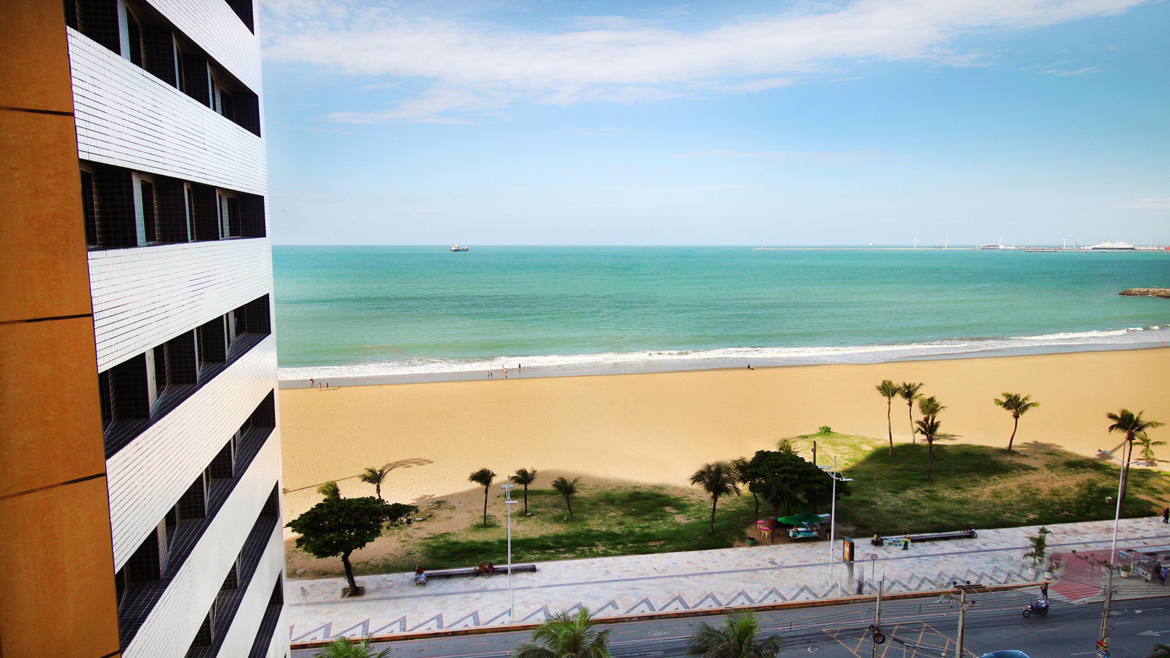 A beach view from a building with a clear sky.
