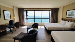 A hotel room with a large window, a bed, a desk, and two chairs. - Holiday Inn Fortaleza by IHG (Fortaleza)