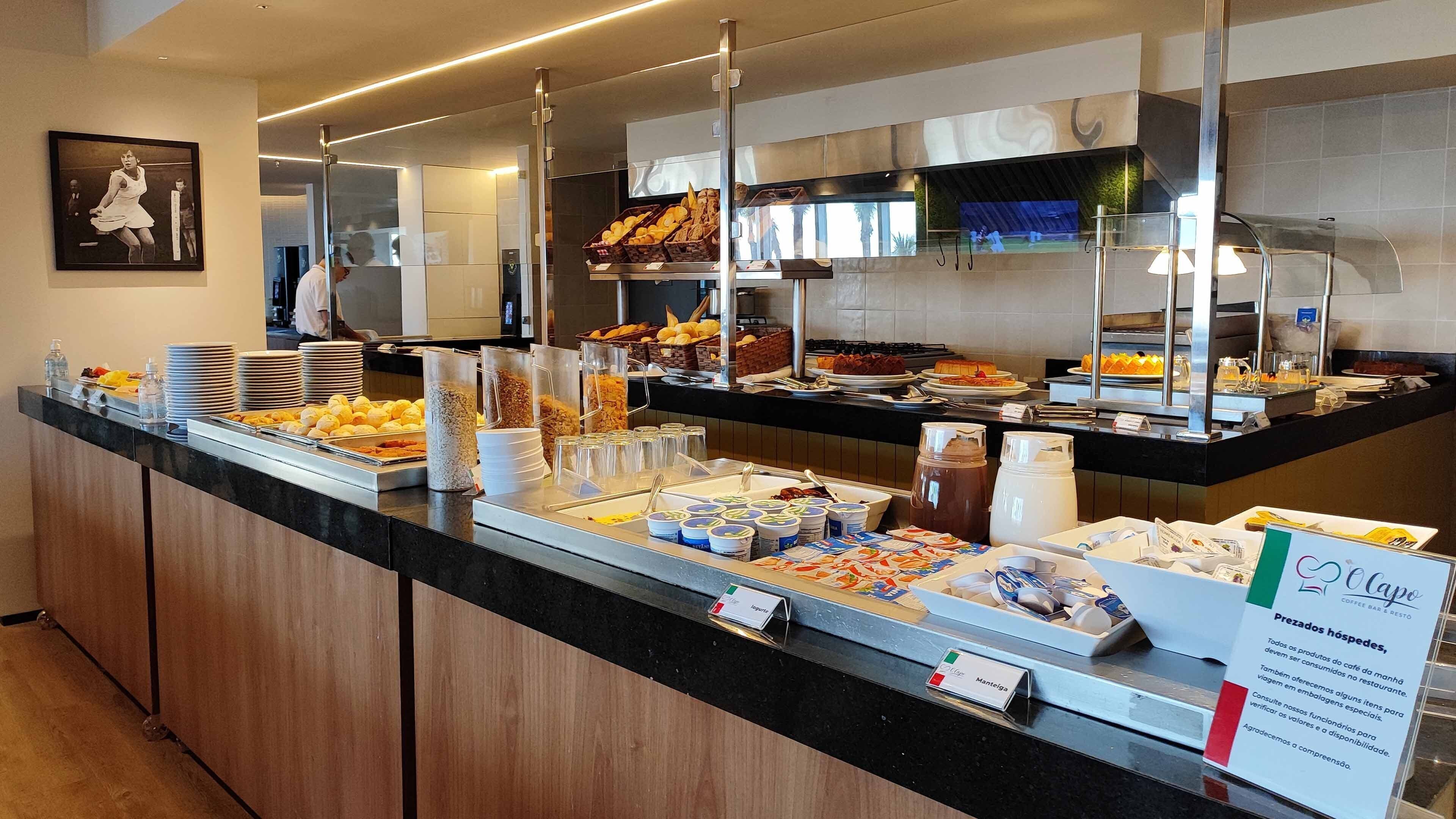 A buffet counter with various food items and a coffee station.