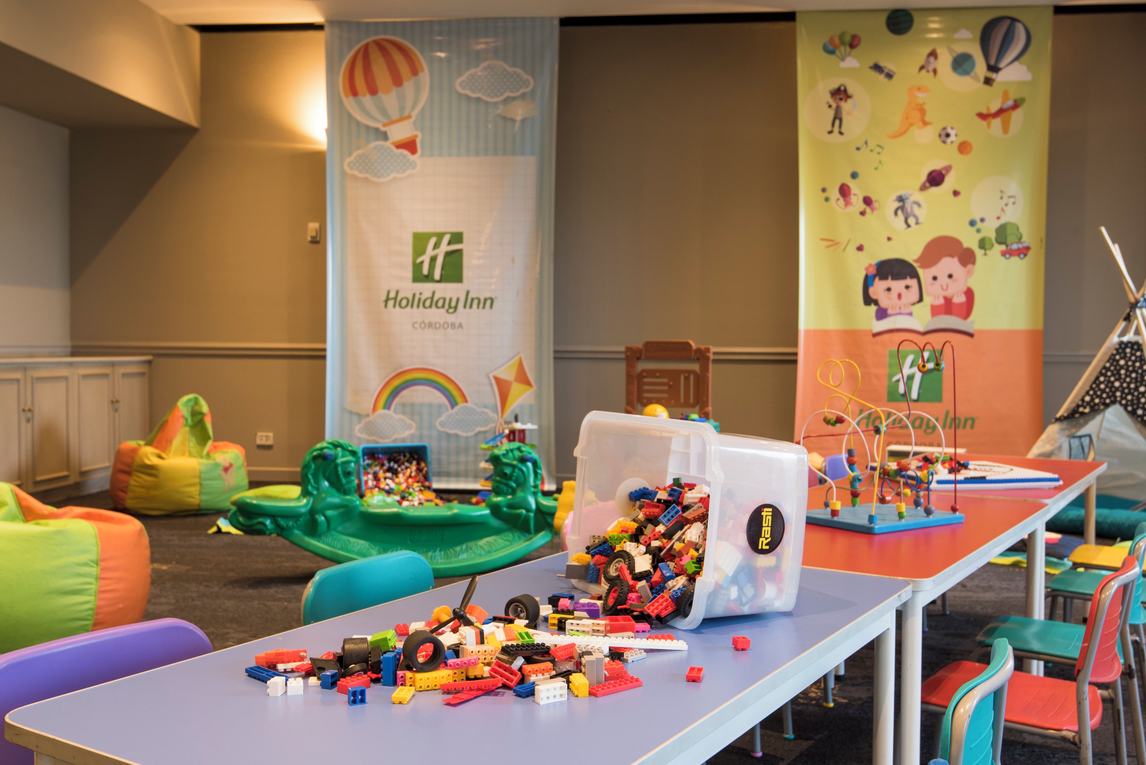 A children's play area with colorful toys and a Holiday Inn sign.